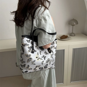 New Chinese-style tote bag with butterfly embroidery and black shoulder strap shown on model