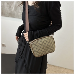 Détail d'un sac bandoulière vintage avec motif trèfle et large bandoulière réglable