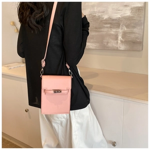 Back view of pink mini crossbody phone bag with silver metal lock on black outfit