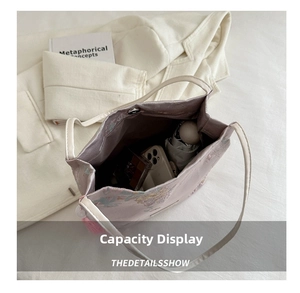 Top view of spacious light purple embroidered satin handbag holding daily essentials