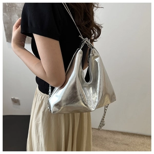 Detail of silver metallic hobo bag with embossed lettering and liquid metal finish