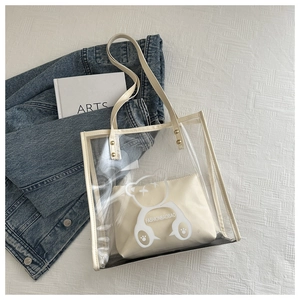 Detail of transparent PVC tote with bear print, leather handles and beige inner pouch