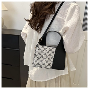 Detail der quadratischen Tasche mit Kleeblatt-Muster und verstellbarem schwarzen Gurt