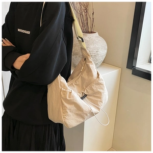 Detail of beige crinkled nylon crossbody bag with drawstring design and wide strap