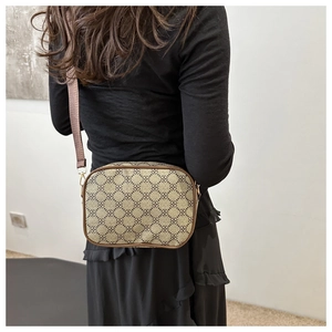 Sac bandoulière marron à monogramme porté par un mannequin pour l'échelle