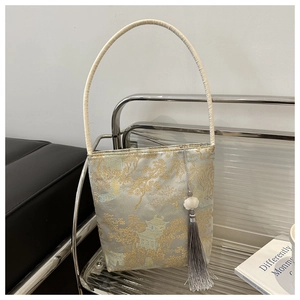 Détail de la broderie en soie et du pompon sur le sac seau au paysage traditionnel