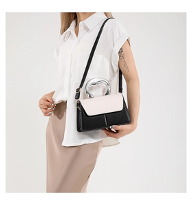 Detail of contrast handbag with silver curved metal handle and premium leather texture