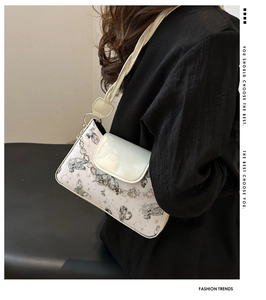 Detail of butterfly print shoulder bag with silver heart chain and FASHION lettering