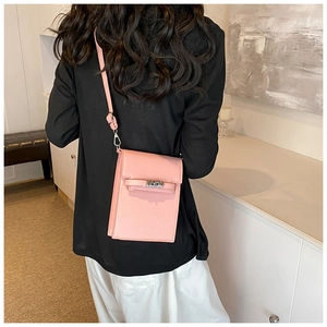 Rear view of a model wearing the pink leather phone bag with a classic buckle design