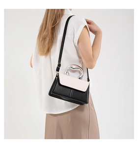 Detail of silver heart-shaped metal handle on color-block PU leather crossbody bag