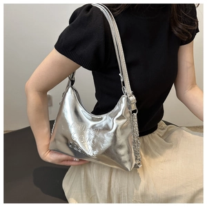 Détail du sac croissant argenté avec logo embossé et bandoulière en chaîne mixte