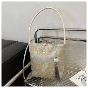 Détail du sac de style chinois avec broderie dorée de pavillon et gland gris