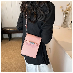 Mini pink vertical leather crossbody bag with metal buckle shown on a model