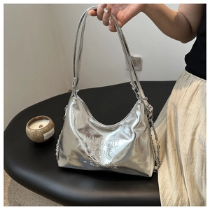 Close-up of metallic silver tote bag featuring embossed logo and glossy PU texture