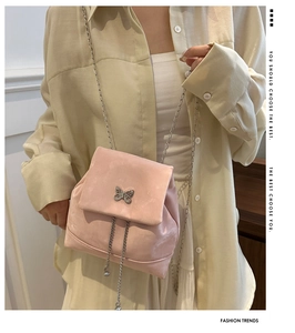 Pink velvet backpack featuring a silver butterfly clasp and delicate chain straps