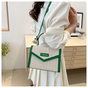 Détail du sac à main en paille tressée avec bordure verte et étiquette de mode