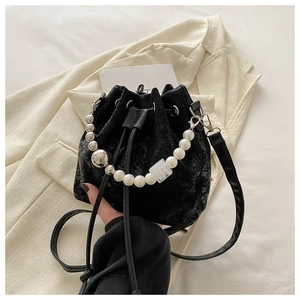 Detail of black drawstring bucket bag with pearl handle and vintage textured finish