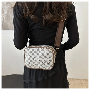 Détail d'un sac bandoulière à motif trèfle marron avec large sangle en nylon réglable
