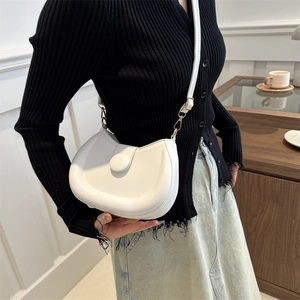 Minimalist white semi-circle crossbody bag with adjustable strap for women in casual setting