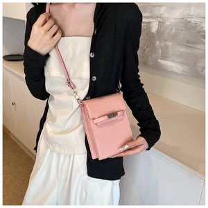 Close-up of pink lychee leather crossbody phone bag with classic metal buckle detail
