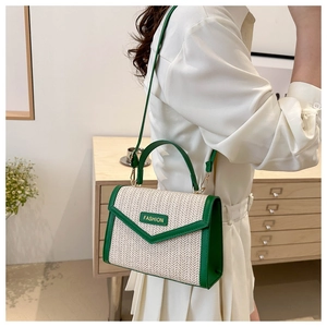 Détail du sac bandoulière en paille verte avec plaque FASHION et texture tissée