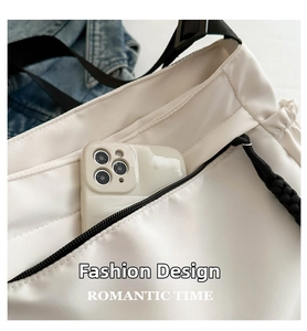 Détail de la poche zippée latérale du sac fourre-tout blanc contenant un smartphone