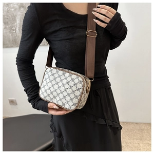 Vue détaillée d'un sac bandoulière vintage à motif trèfle et large sangle marron réglable