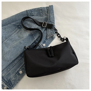Minimalist black Oxford fabric crossbody bag with chain detail and adjustable strap