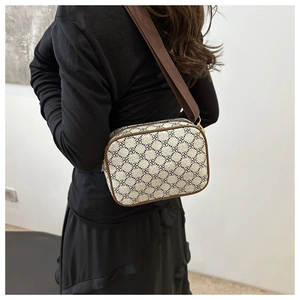 Détail du sac bandoulière avec motif monogramme marron et large sangle réglable