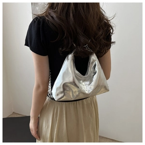 Silver metallic hobo bag detail with embossed lettering and thick metal chain strap