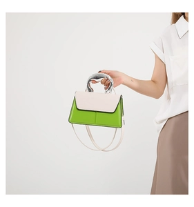 Detailed view of lime green and pink small square bag with polished silver top handle