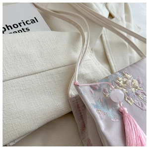 Gros plan sur la broderie jacquard rose du sac avec détails de longs glands en soie