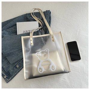 Détail du sac cabas en PVC transparent avec imprimé ours et anses en similicuir beige