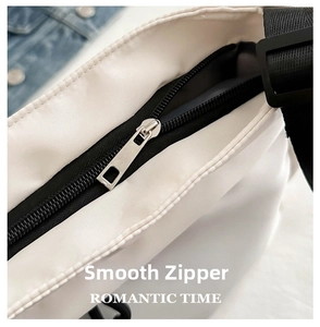 Détail de la fermeture éclair noire et bandoulière en nylon sur un sac fourre-tout