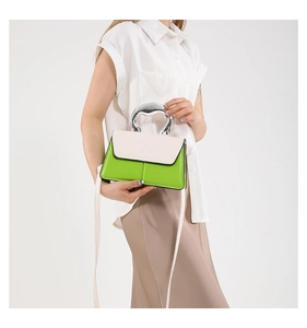 Detail of green and beige crossbody bag with unique liquid metal silver handle and strap
