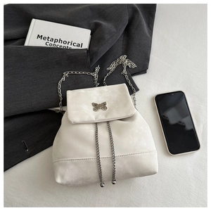 Detail of cream white PU leather backpack with butterfly buckle and silver chain straps
