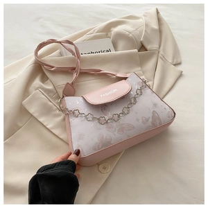 Close-up of pink butterfly print handbag with floral metal chain and fashion lettering