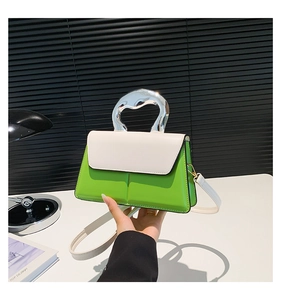 Détail du sac bandoulière bicolore avec poignée métallique argentée et cuir vert vif