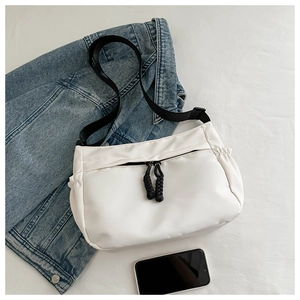 Détail d'un sac cabas en nylon blanc avec fermetures en corde noire et bandoulière large