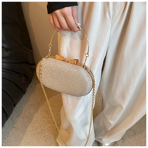 Detail of champagne gold evening bag with glitter surface and metal ring handle