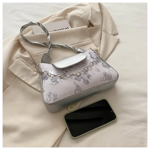 Detail of purple butterfly print shoulder bag with silver leather and metal flower chain