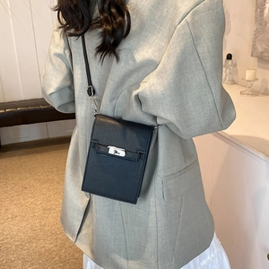 Classic black leather mini crossbody bag with silver turn-lock clasp on a model