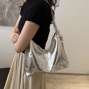 Silver metallic hobo shoulder bag with embossed letters and chain strap on a model