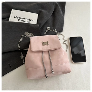 Detail of pink faux suede mini backpack with silver butterfly clasp and chain strap