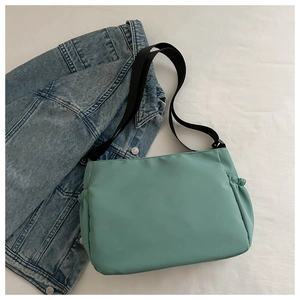Détail du sac cabas vert menthe avec bandoulière noire réglable et poche latérale froncée