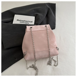 Close-up of pink suede backpack featuring silver chain strap and neat stitching details