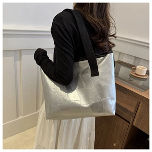 Silver geometric tote bag with metallic patchwork texture shown on a female model