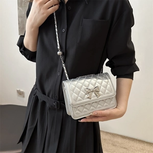 Chic silver quilted shoulder bag with metal bow detail and adjustable chain strap