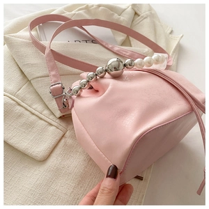 Detailed view of pink ruched cloud bag with large pearl and silver bead handle and strap