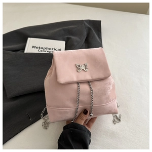 Detail view of pink velvet backpack with silver butterfly charm and chain drawstring
